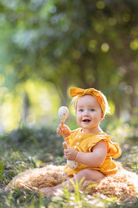 Portrait of cute little caucasian baby girl ten months old playing in summer park. 