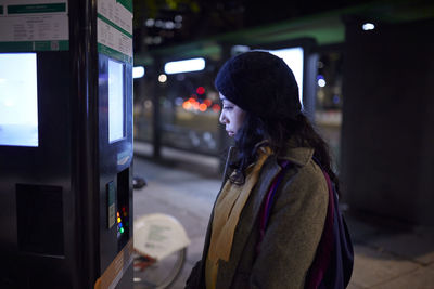 Woman using atm at night