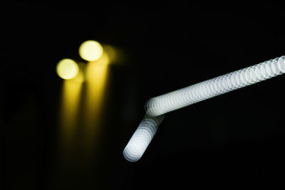Close-up of illuminated electric lights over black background
