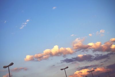 Low angle view of power lines against cloudy sky