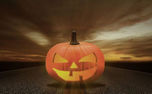 Close-up of illuminated pumpkin against orange sky during sunset