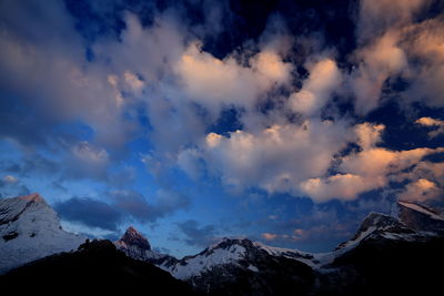 Low angle view of snowcapped mountains against sky 