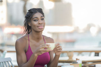 Portrait of young woman drinking coffee