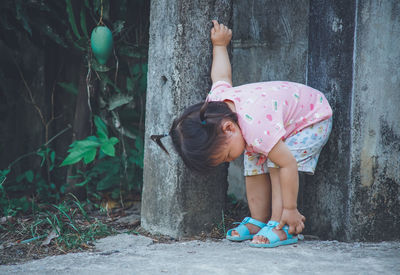 Baby girl bending against wall