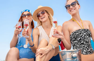 Smiling women holding champagne flute outdoors