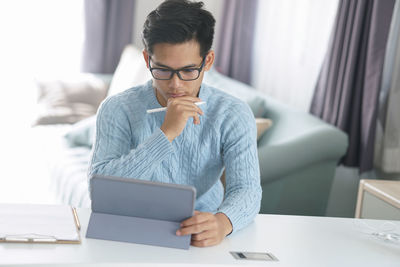 Man using mobile phone while sitting on table