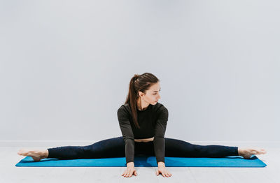 Gymnast stretching against white background