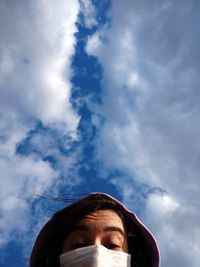 Low angle view of man looking through clouds