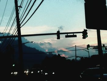 Low angle view of street lights against sky at sunset