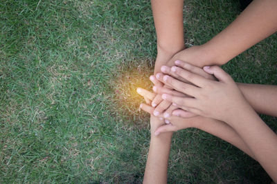 Midsection of woman hand holding cigarette on field