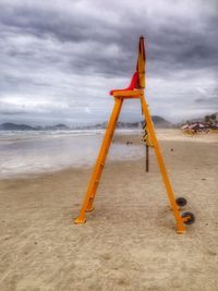 Scenic view of beach against cloudy sky