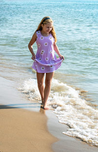 A young girl walks on a pretty beach in michigan usa