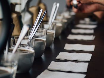 Row of coffee cups and tissue papers on table at restaurant