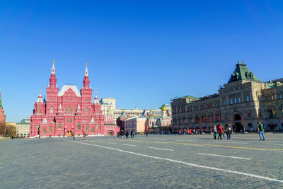 Buildings in city against clear blue sky