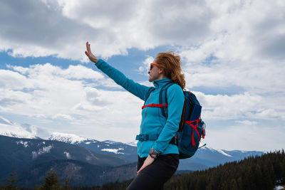 Rear view of couple standing on mountain against sky