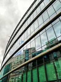 Low angle view of glass building against sky