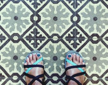 Low section of person standing on tiled floor