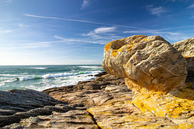 Rock formation on beach against sky