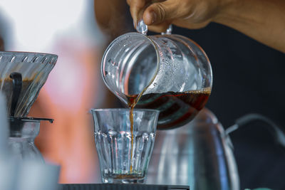 Close-up of hand pouring wine in glass