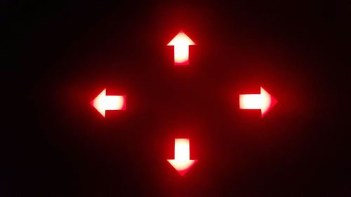 Close-up of illuminated sign against black background