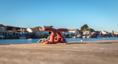 Close-up of pier on beach against clear blue sky