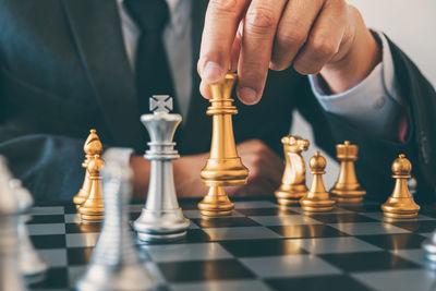 Midsection of person playing chess on board