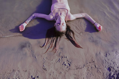 High angle view of woman lying down on sand