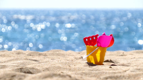 Close-up of toys on beach against sky