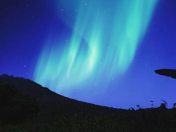 Low angle view of silhouette mountain against sky at night