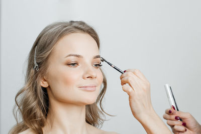 Portrait of woman making face against gray background