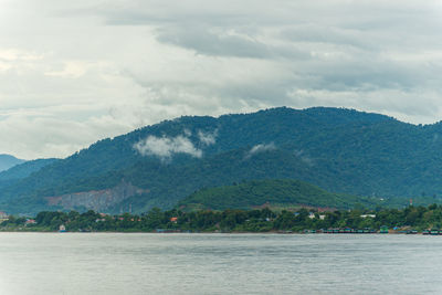 Scenic view of sea and mountains against sky