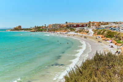 Scenic view of beach against clear blue sky