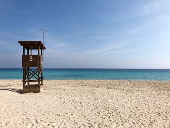Lifeguard hut on beach against sky