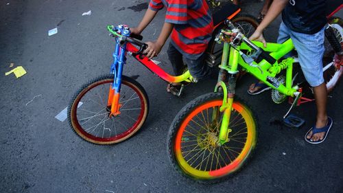 Low section of people with bicycle on road