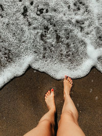 Low section of person standing on beach