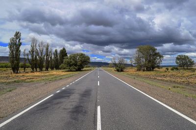 Empty road against cloudy sky