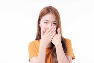Portrait of young woman against white background