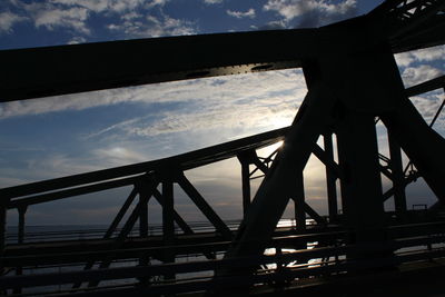 Low angle view of bridge against cloudy sky