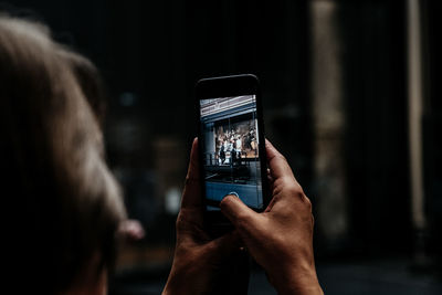 Rear view of woman photographing with mobile phone