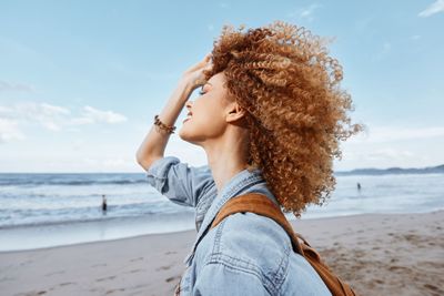 Side view of woman standing at beach