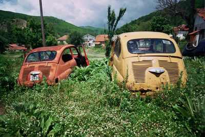 Abandoned vehicle on landscape against sky