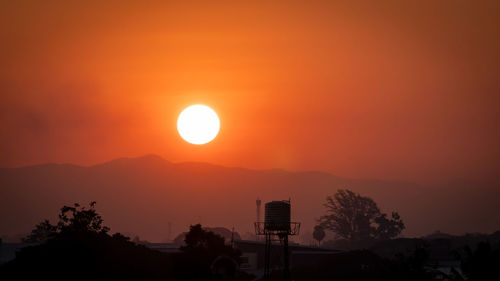 Scenic view of silhouette mountains against orange sky