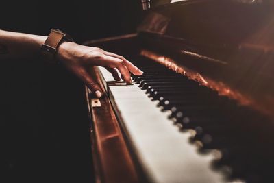 Cropped hand of man playing piano