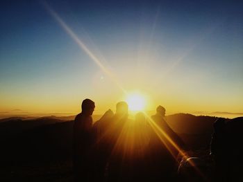 Silhouette people against clear sky during sunset