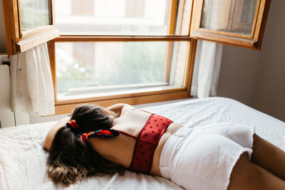 High angle view of woman lying on bed at home