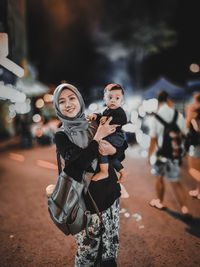 Portrait of friends standing on street at night