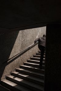 Rear view of man moving up on steps