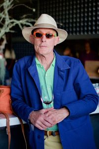 Portrait of senior man wearing sunglasses standing by table