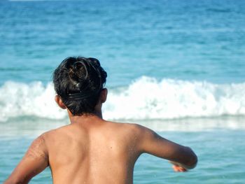 Rear view of man in water in front of sea