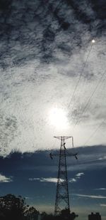 Low angle view of silhouette electricity pylon against sky